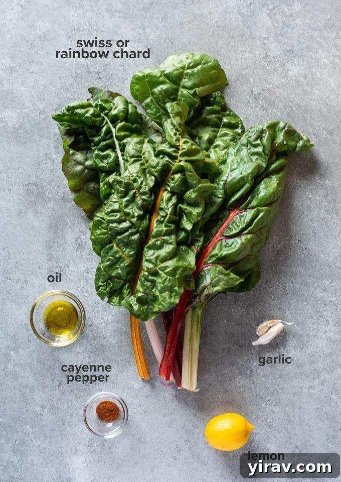 Garlicky Sautéed Swiss Chard 4 Fresh ingredients for sautéed Swiss chard, including a bunch of rainbow chard, garlic, lemon, oil, and spices, laid out on a wooden board.