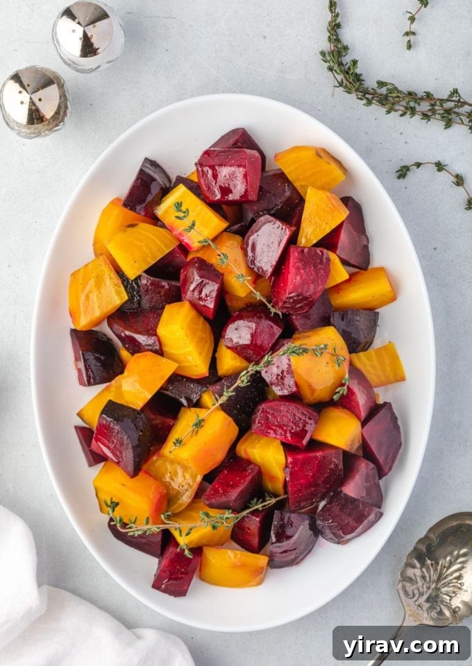 Roasted beets on a platter with thyme sprigs, showcasing their vibrant color and tender texture.