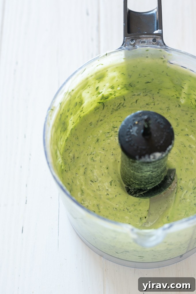 The Perfect Green Goddess Dressing 6 Green Goddess dressing being blended in a food processor, showing its creamy transformation.
