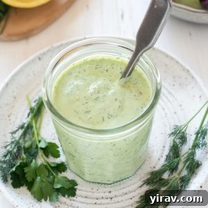 The Perfect Green Goddess Dressing 9 Green goddess dressing in a jar with a spoon, ready to be served.