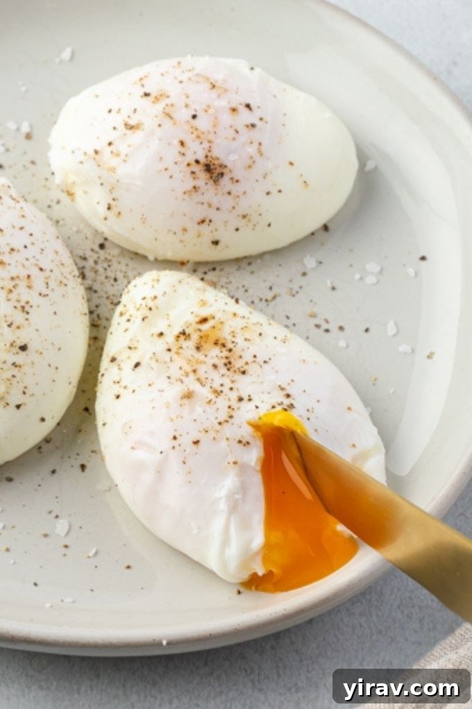 Knife cutting into a poached egg on a plate