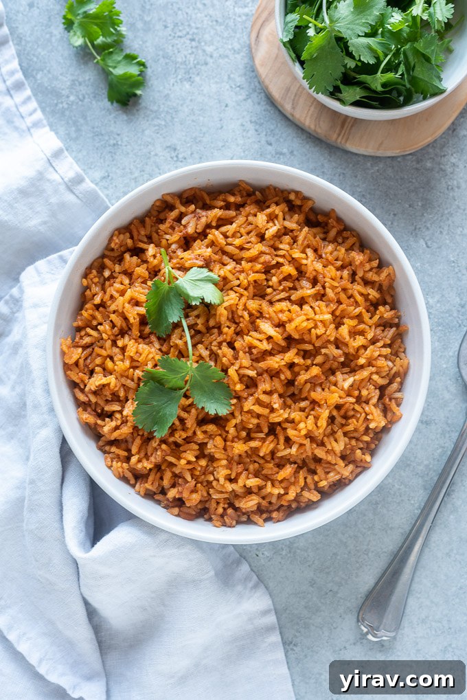 Easy Mexican rice in a serving bowl topped with cilantro sprig, ready to be served