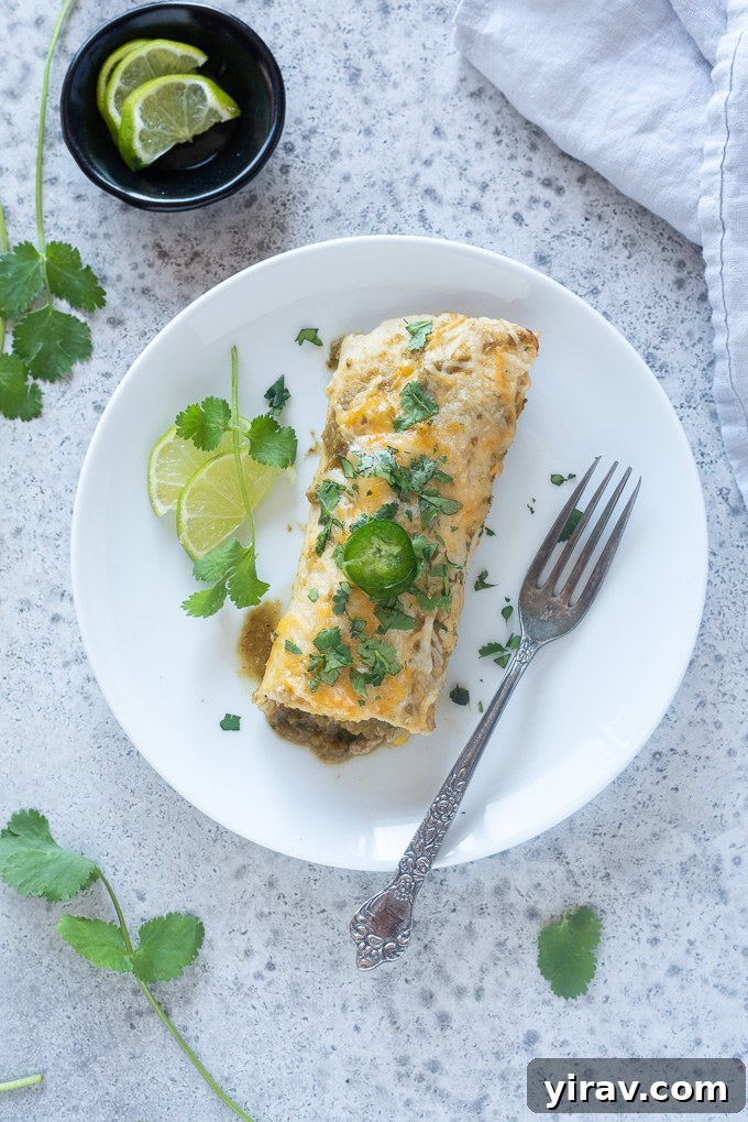Lean Green Turkey Enchiladas 6 A single ground turkey enchilada on a plate with a fork.