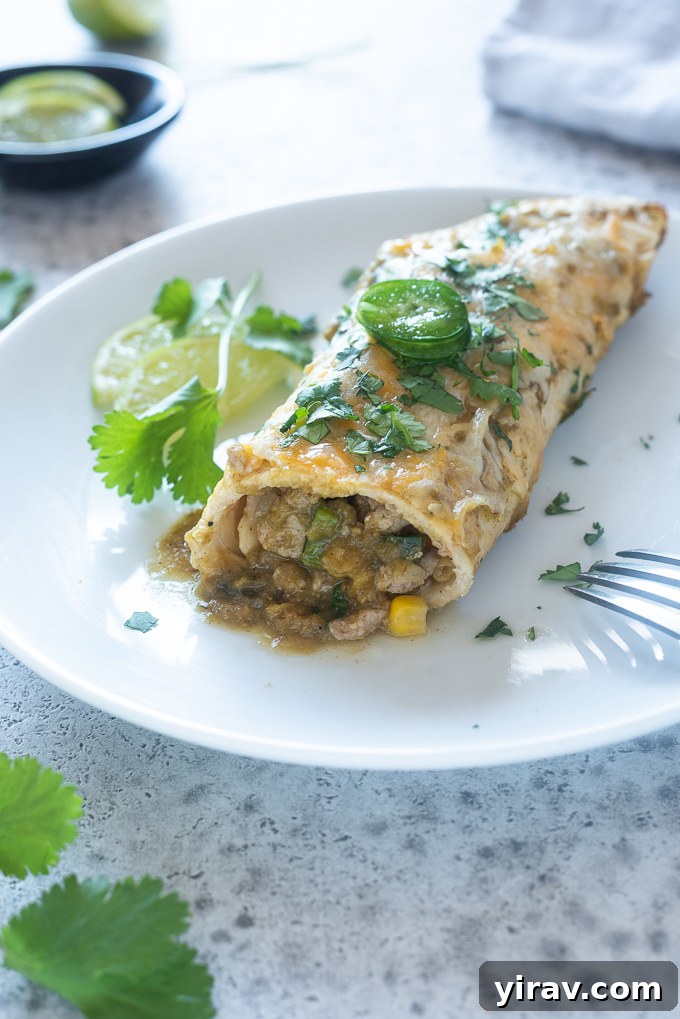 Lean Green Turkey Enchiladas 7 A ground turkey enchilada with green sauce on a plate, garnished with fresh herbs.