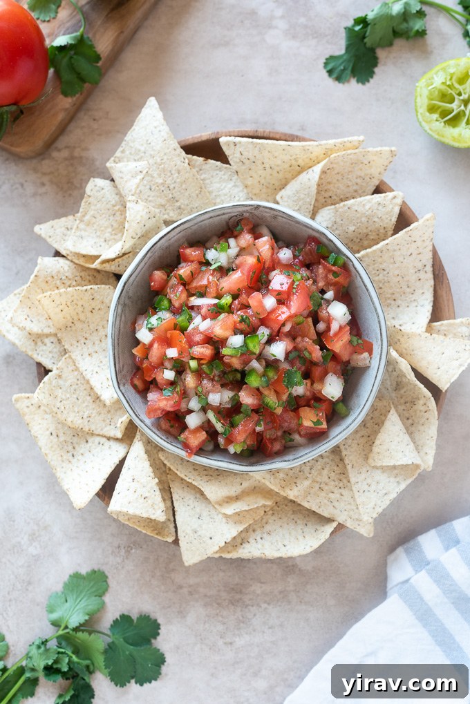 Homemade pico de gallo in a bowl surrounded by tortilla chips
