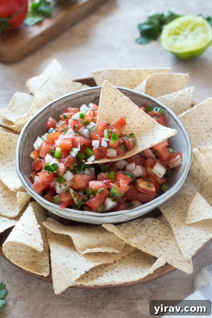 Tortilla chip in bowl of homemade pico de gallo