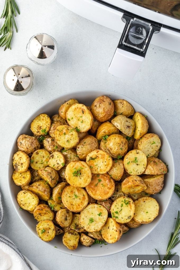Air fryer roasted potatoes in a bowl by an air fryer