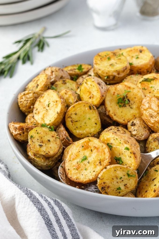 Air fryer roasted potatoes in a bowl with rosemary