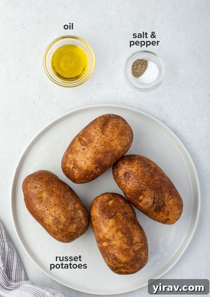 Air fryer baked potatoes recipe ingredients laid out, including russet potatoes, oil, salt, and pepper