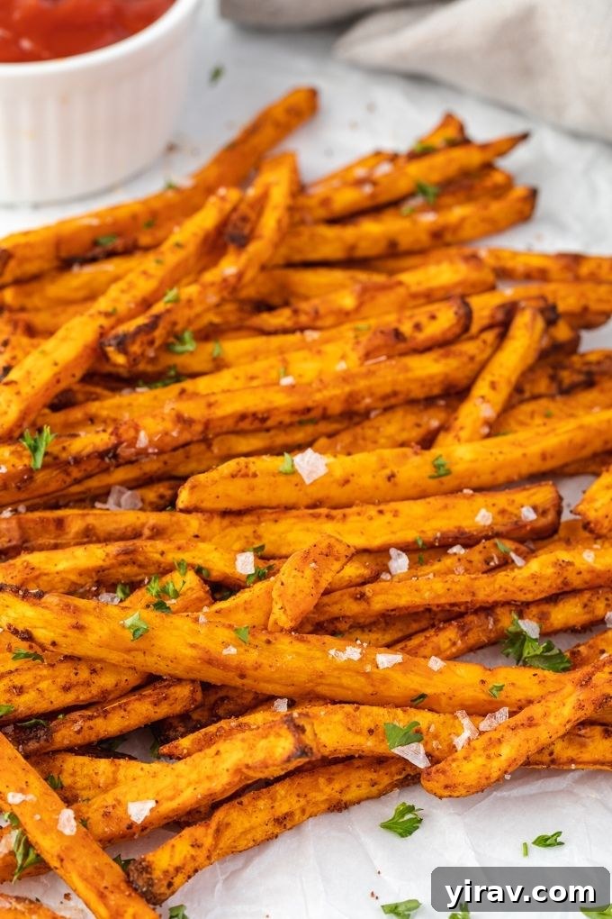 Air fryer sweet potato fries topped with flaky sea salt and parsley