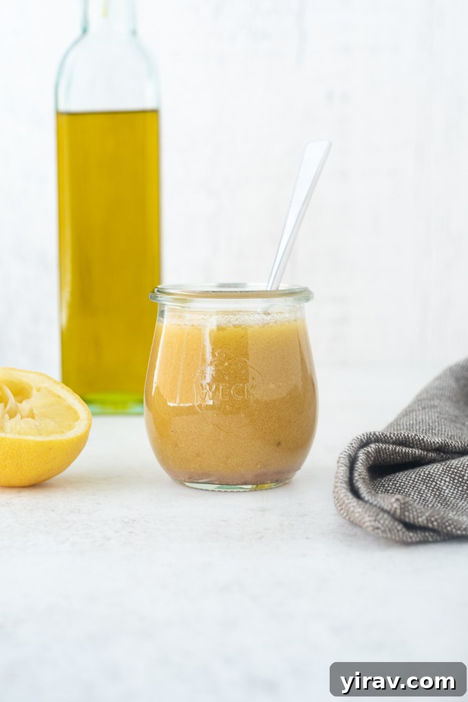 Red wine vinaigrette in a jar with olive oil and lemon aside