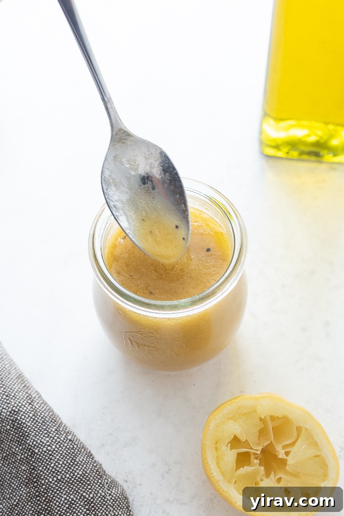 Red wine vinaigrette drizzling off of a spoon into a jar