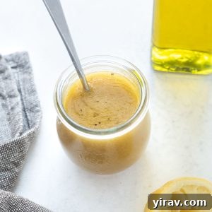 Jar of red wine vinaigrette with spoon in it