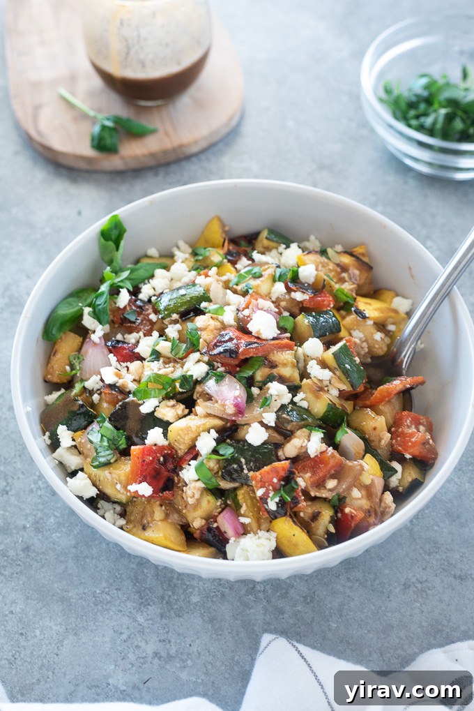 A close-up shot of grilled vegetable salad in a white bowl, showcasing the vibrant colors and textures.