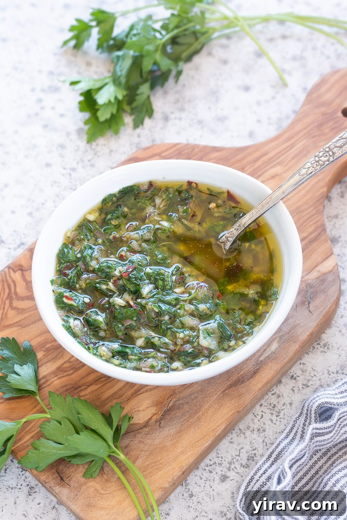 Fresh chimichurri sauce in a bowl on a rustic cutting board, ready for serving.