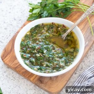 Chimichurri sauce in a bowl with a spoon inside, showcased beautifully in a recipe card format.