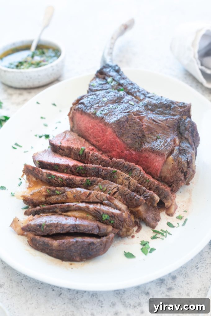 Perfectly grilled and sliced Tomahawk Steak resting on a platter, ready to be served.