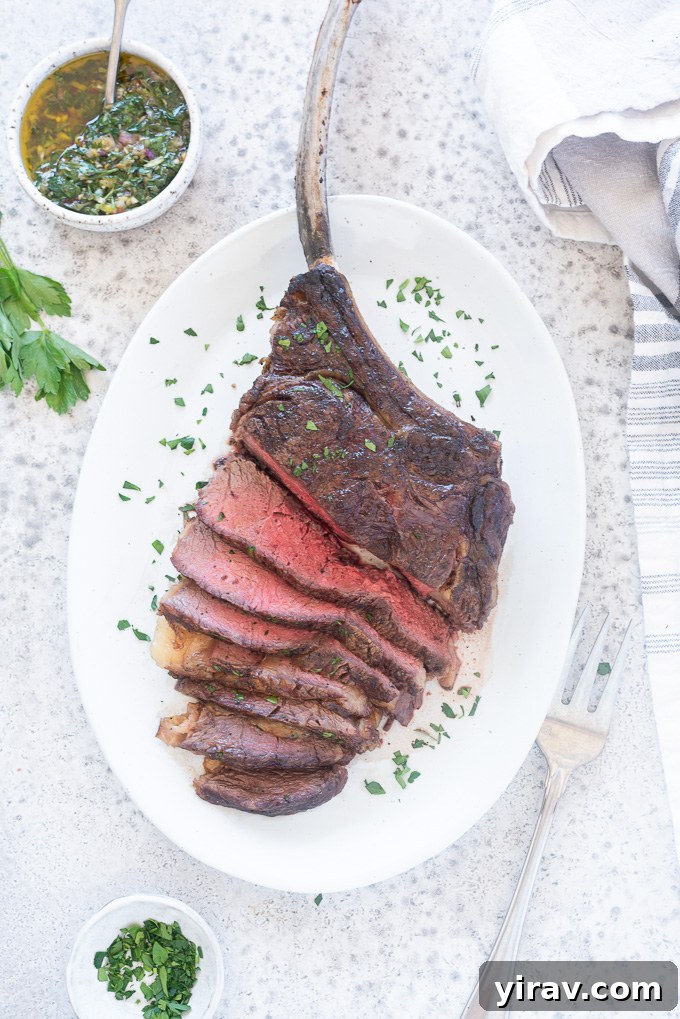 Grilled Tomahawk steak, beautifully sliced and arranged on a white platter, garnished with fresh chopped parsley.