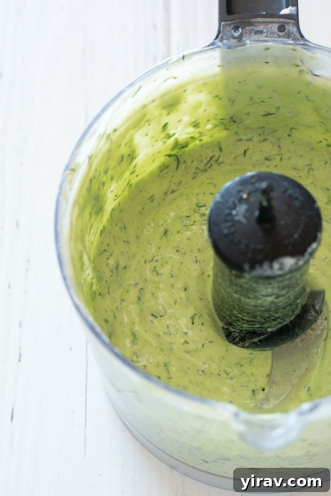 Creamy salad dressing being blended in a food processor, highlighting the process of achieving a smooth and consistent texture.