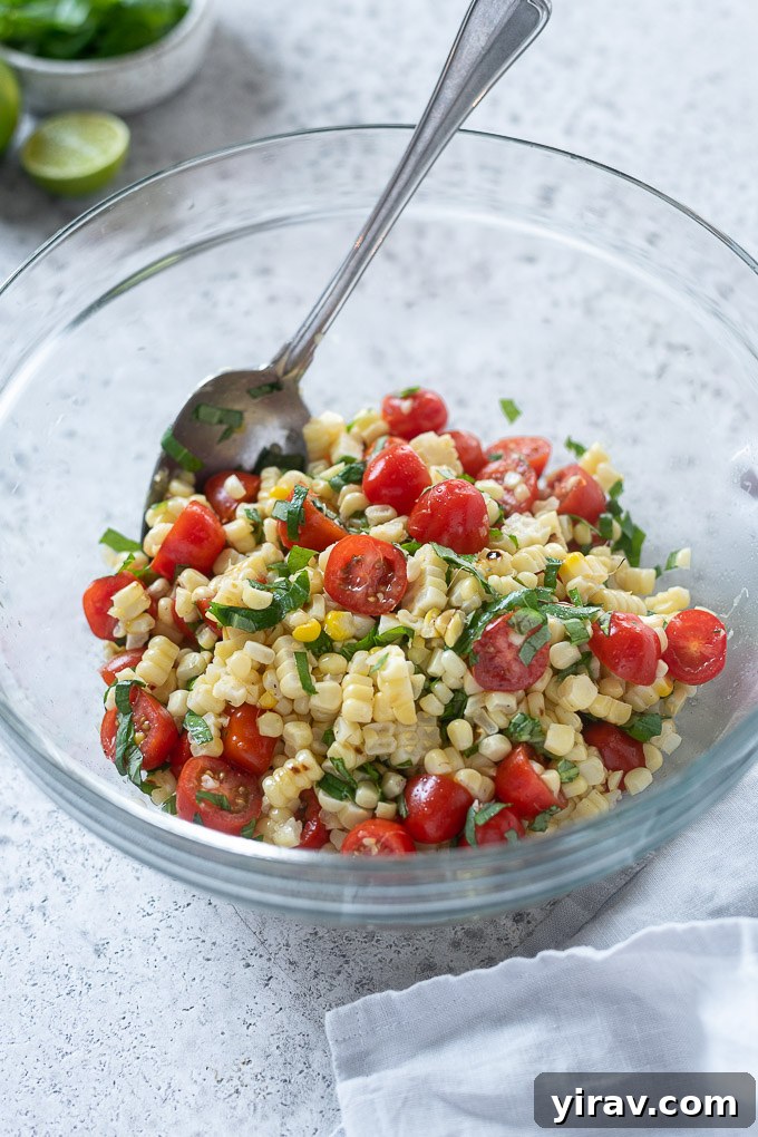 Vibrant Summer Corn and Tomato Medley 6 Fresh corn and tomato salad tossed in a mixing bowl with basil, ready to be served