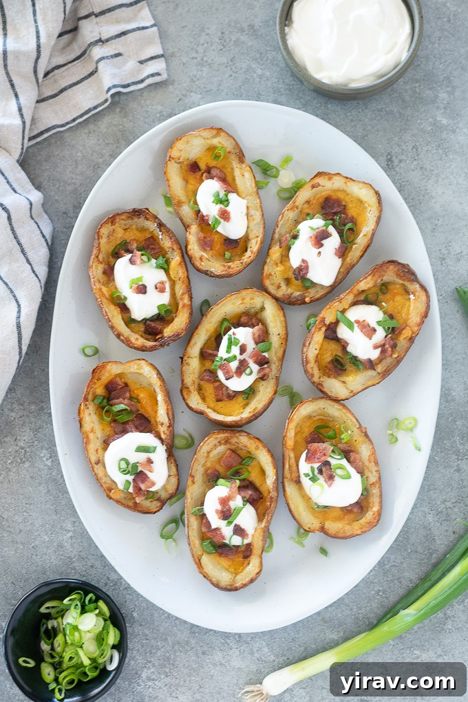 Platter of loaded potato skins garnished with fresh scallions and sour cream for a party