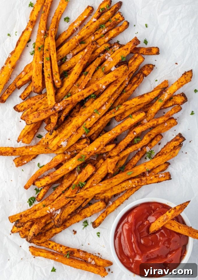 Air Fryer Magic: 15+ Effortless Meals 24 Air fryer sweet potato fries on parchment with ketchup