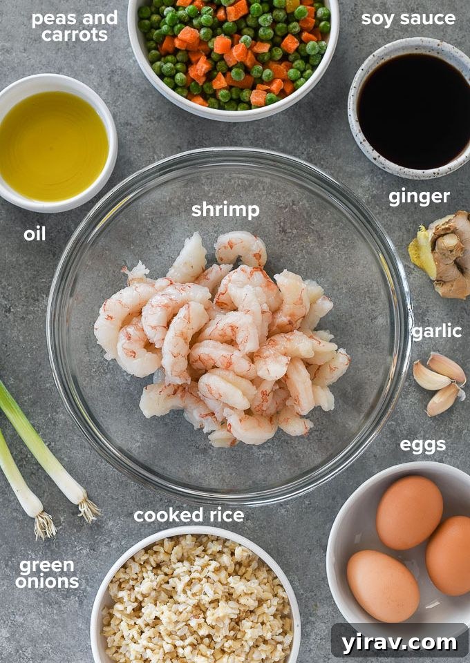 Collection of fresh ingredients for shrimp fried rice, including shrimp, rice, peas, carrots, and sauces