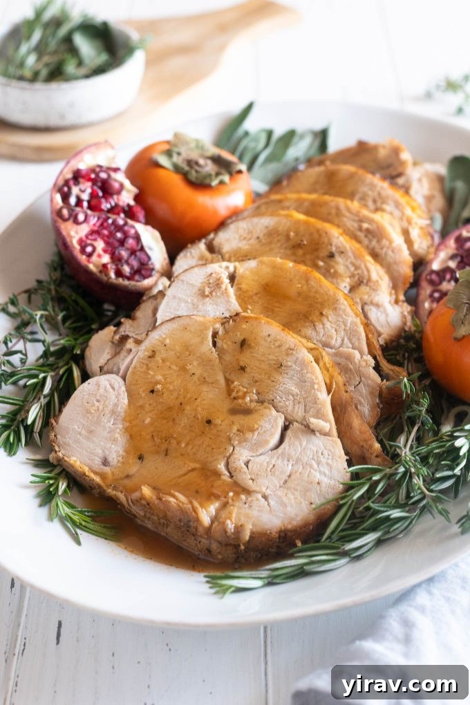 Succulent slices of roasted boneless turkey breast drizzled with rich homemade gravy, presented beautifully on a serving platter.