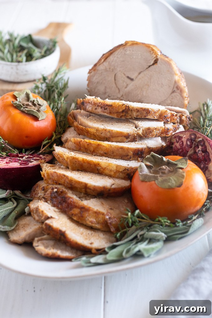 Elegantly arranged slices of roasted boneless turkey breast on a pristine white platter, ready to be served and enjoyed.