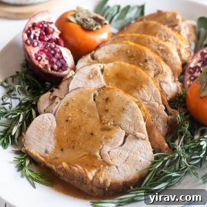Boneless turkey breast sliced and covered with gravy, showcasing its juiciness and deliciousness.