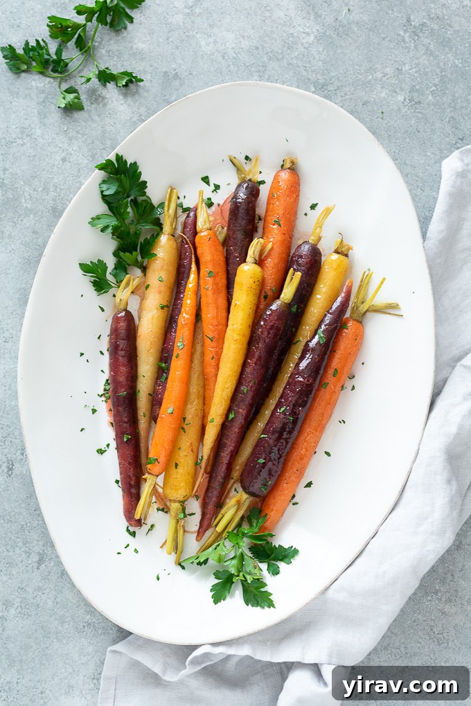 Glazed carrots on a white serving dish with a linen alongside