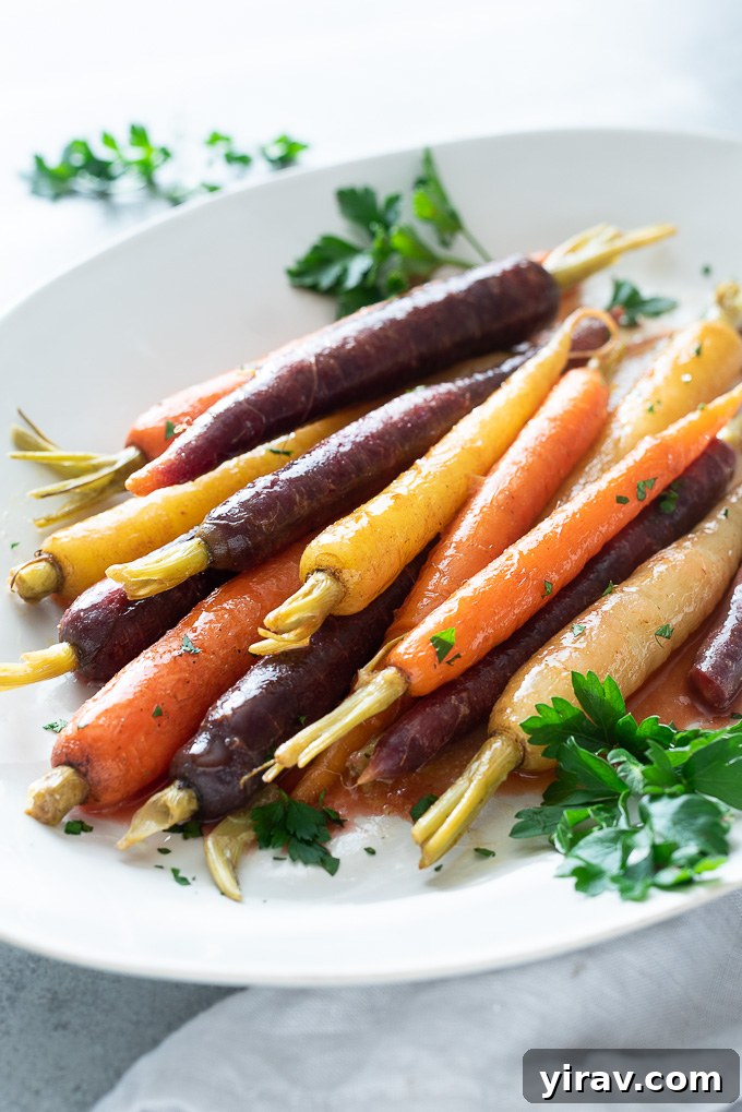 Glazed carrots on a white serving plate with fresh parsley