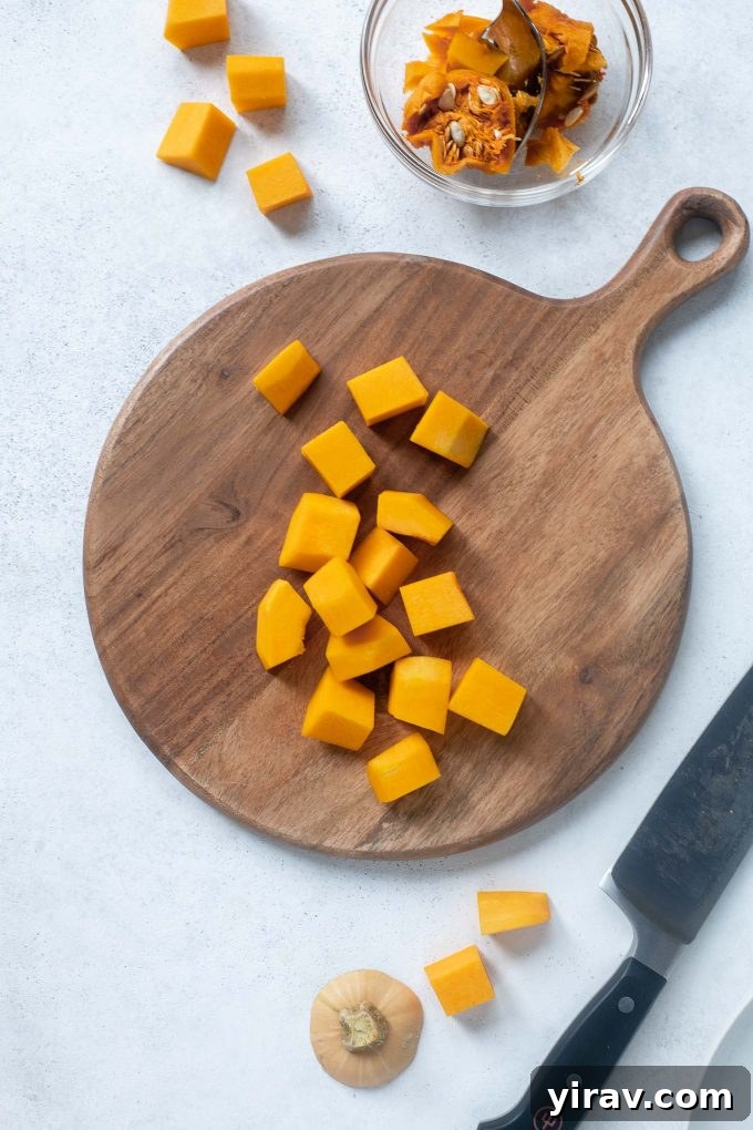 Effortless Butternut Squash Preparation 2 Freshly cubed butternut squash on a wooden cutting board, ready for cooking.
