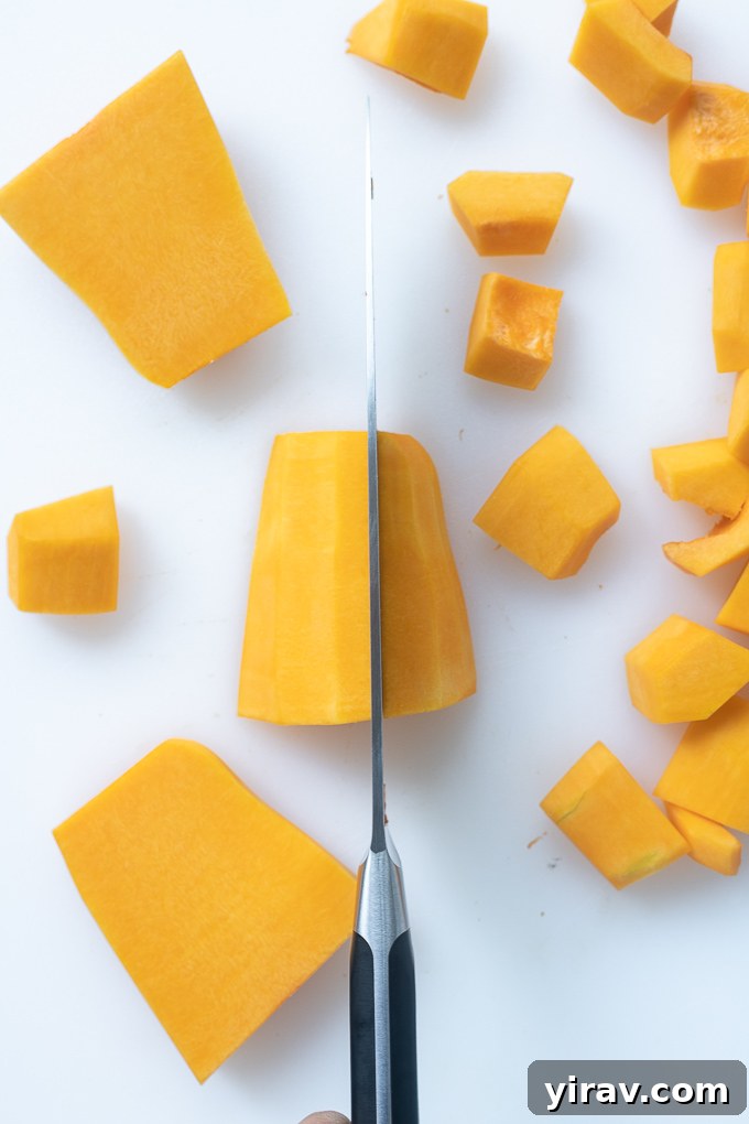 Effortless Butternut Squash Preparation 8 Perfectly cubed butternut squash pieces neatly arranged in a single layer on a cutting board, showcasing consistent size.