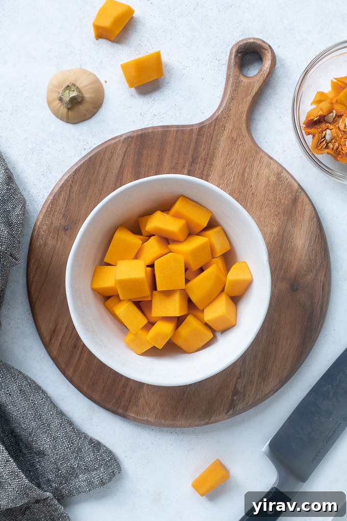 Effortless Butternut Squash Preparation 9 A bowl filled with vibrant orange, freshly cubed butternut squash, ready to be used in recipes or stored.