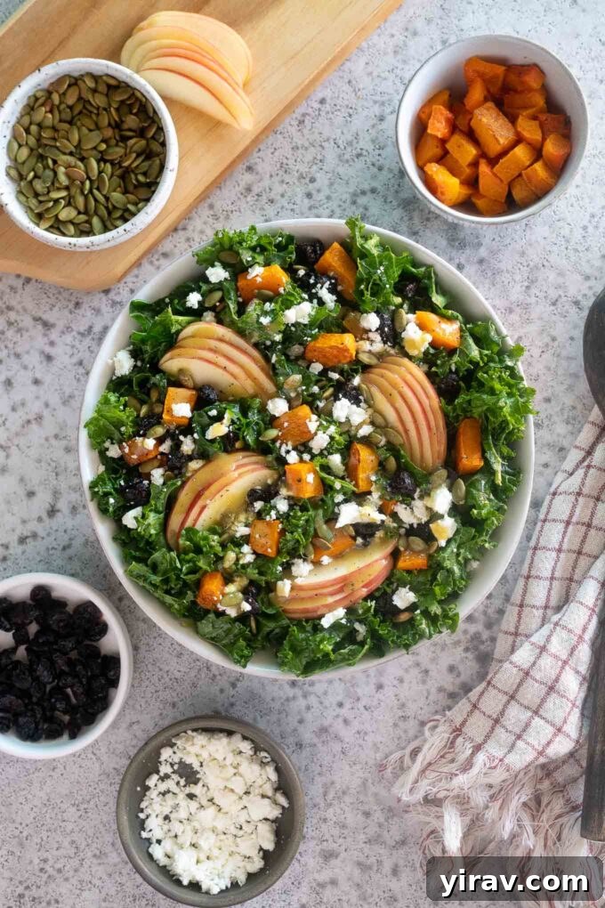 A vibrant Fall Harvest Salad in a large wooden bowl, garnished with roasted butternut squash cubes, crisp apple slices, crumbled feta cheese, and toasted pepitas. The salad is tossed with a light apple cider vinaigrette, with individual ingredients artfully arranged on a rustic wooden surface alongside the bowl, hinting at the fresh, wholesome components.