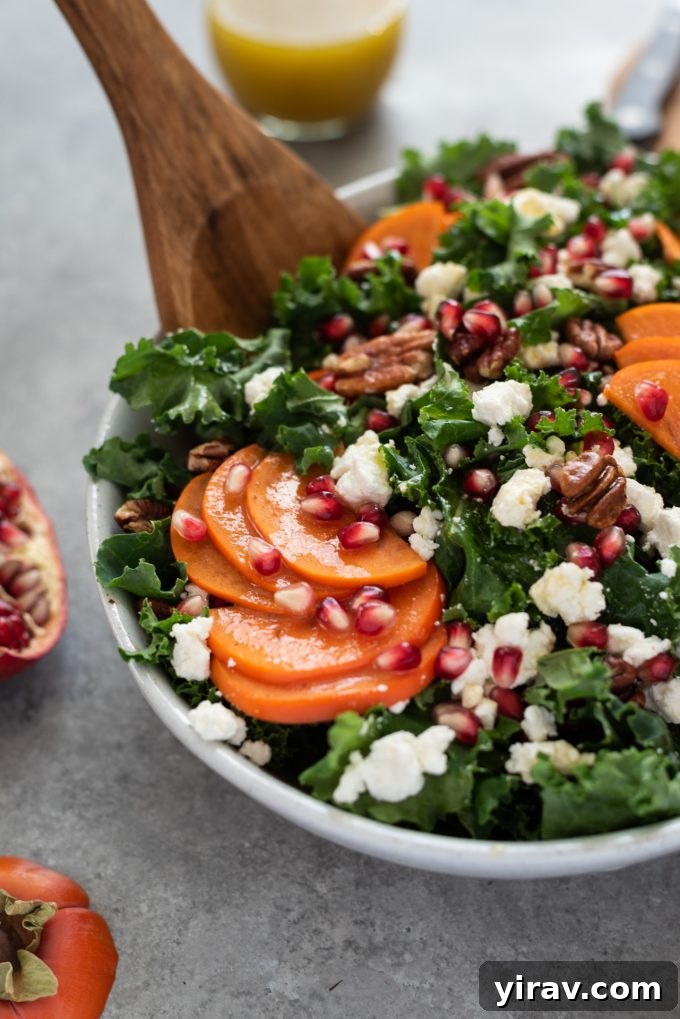 A festive Holiday Salad in a bowl, showcasing vibrant kale, persimmon, and pomegranate.