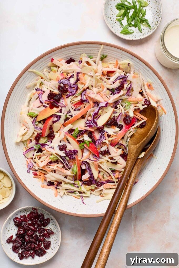 Overhead shot of apple fennel slaw in a bowl with wooden servers.
