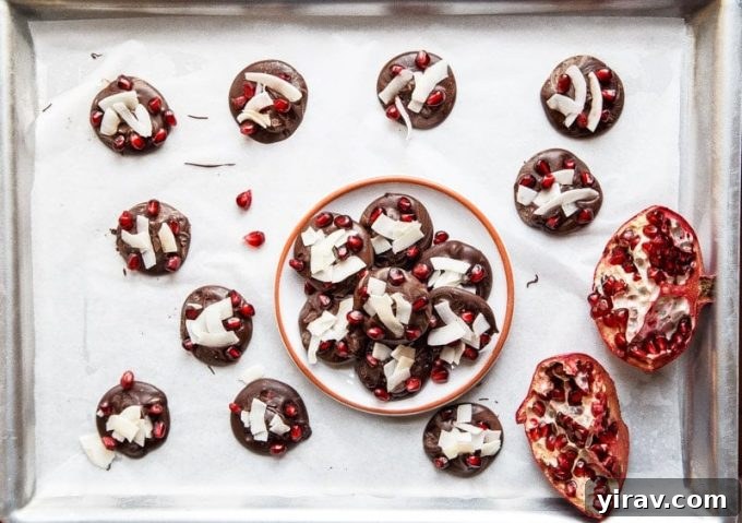 Close-up of Chocolate Pomegranate Bark, revealing rich dark chocolate studded with bright pomegranate arils and shredded coconut.