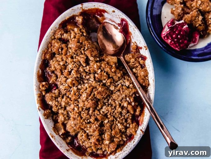 A comforting Pear and Pomegranate Crumble, flavored with orange zest and vanilla paste.