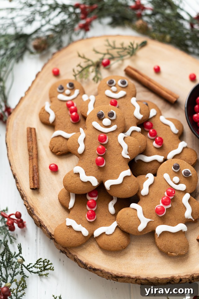 Beautifully decorated gingerbread man cookies arranged on a wooden serving board, showcasing holiday cheer.