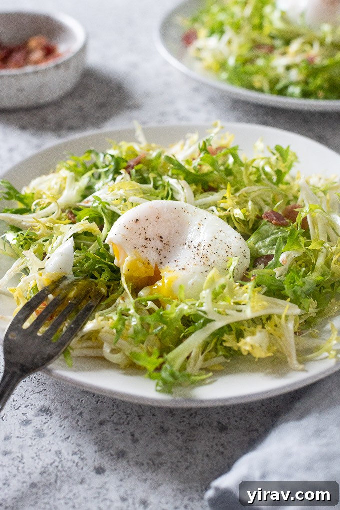 A close-up of Salade Lyonnaise on a plate, with a fork gently breaking the yolk of a perfectly poached egg, allowing it to spill over the frisée and bacon.