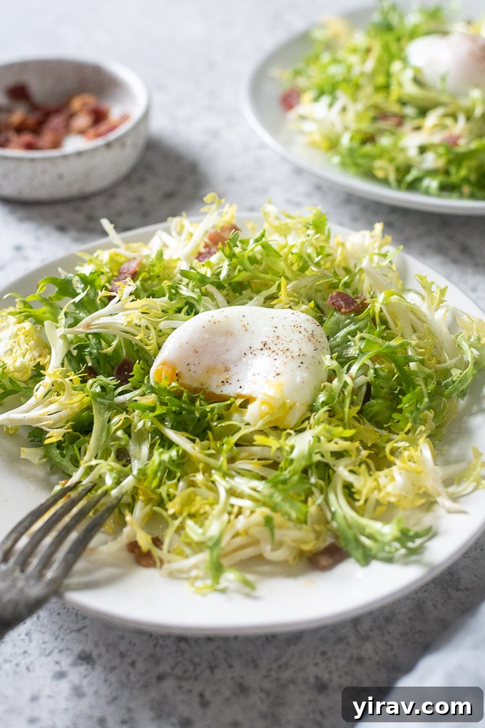 A beautifully plated Lyonnaise salad with a golden poached egg, crispy bacon, and frisée, ready to be served.
