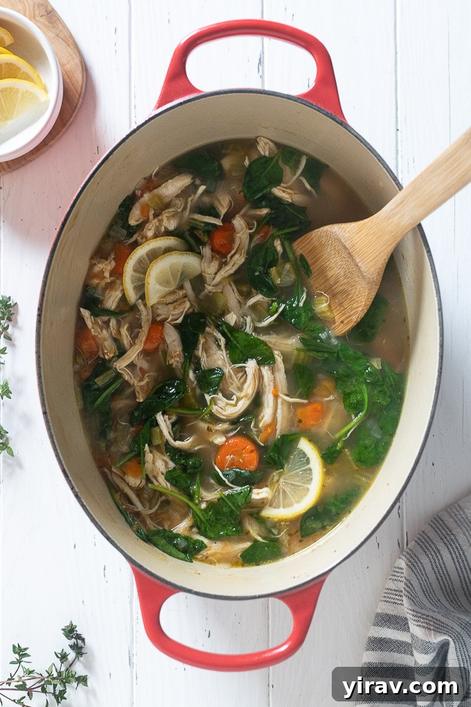 Healthy chicken vegetable soup simmering in a Dutch oven on the stove