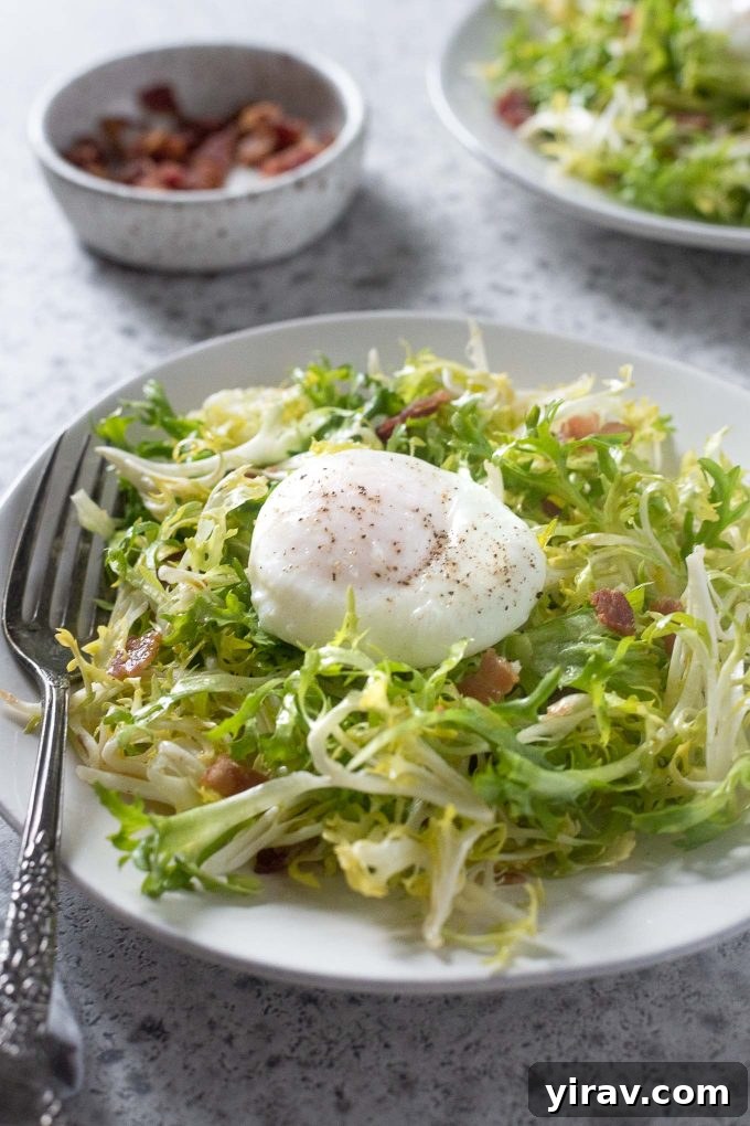 Salade Lyonnaise on a plate of frisée lettuce, topped with a poached egg and bacon