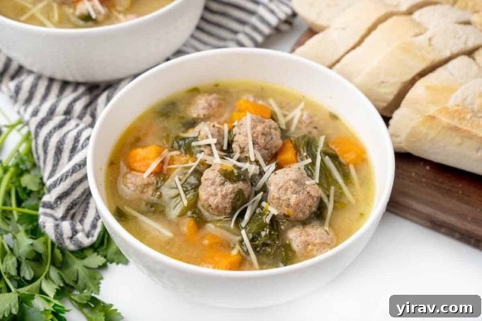 Bowl of Italian Wedding Soup with small meatballs and greens