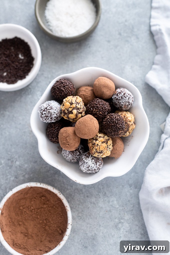 Close-up of smooth, dark chocolate truffles glistening in a white ceramic bowl.