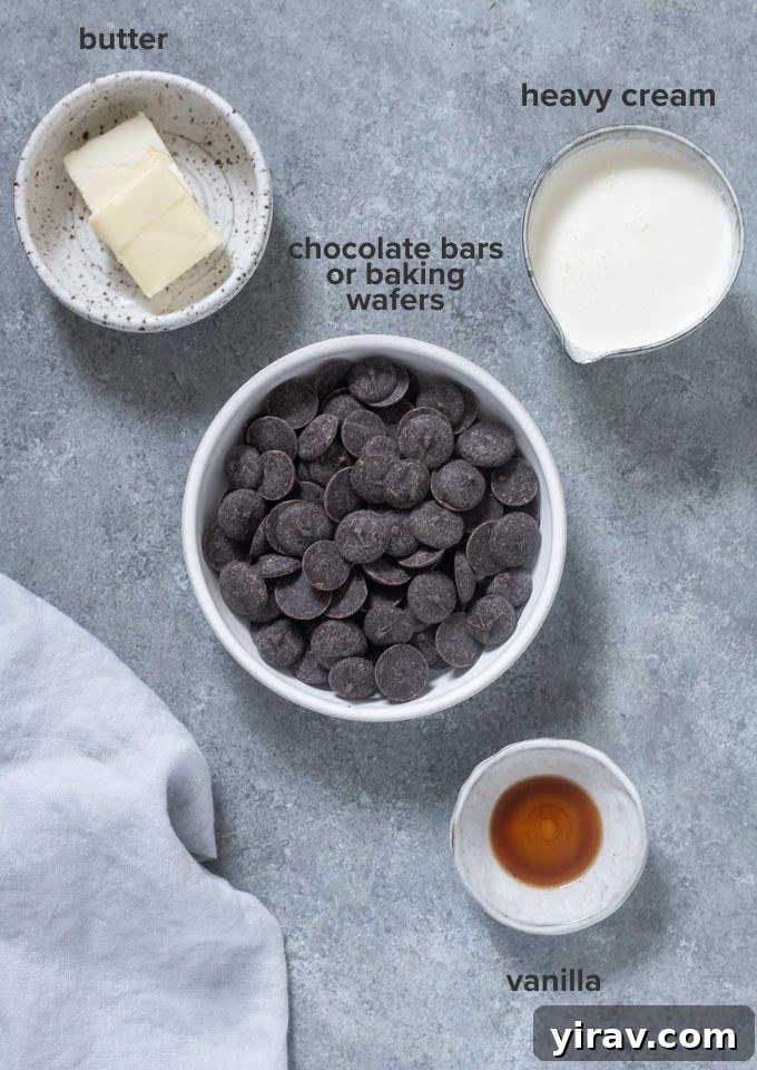 Key ingredients for chocolate truffles including chocolate bars, heavy cream, butter, and vanilla extract.
