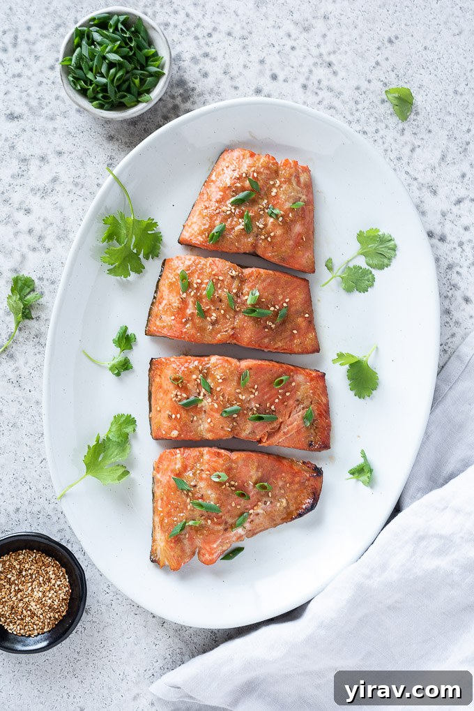 Miso marinated salmon on a platter with sesame seeds and scallions