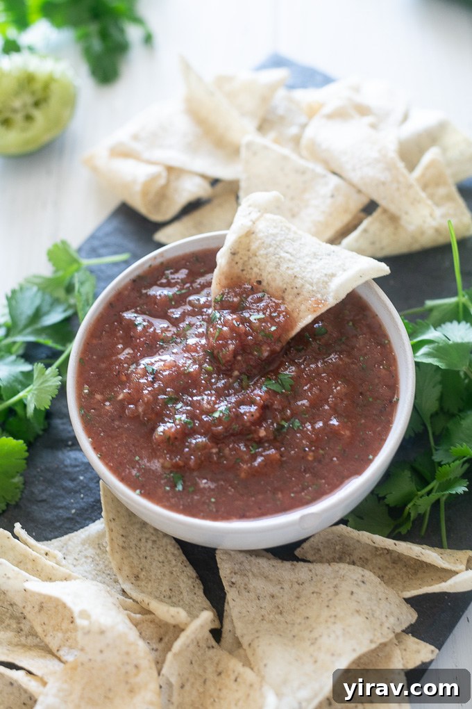 Restaurant salsa in a bowl with chip dunked in the middle